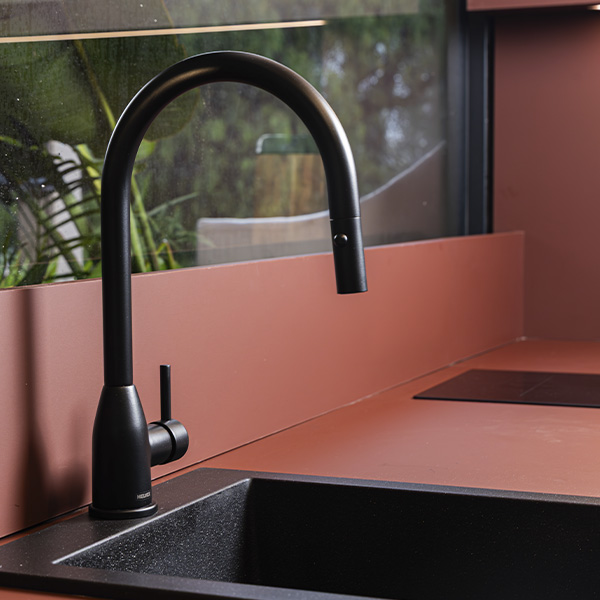 WC ahorrador de agua color blanco con un fondo en tonos oscuros dentro de un baño de la Design House